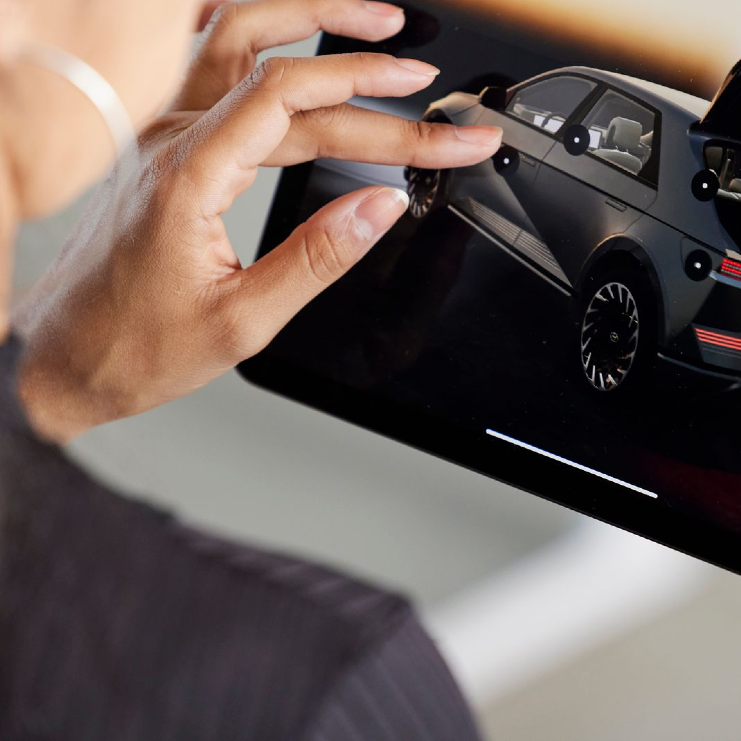 Person interacting with a 3D visualisation of a car on a tablet device