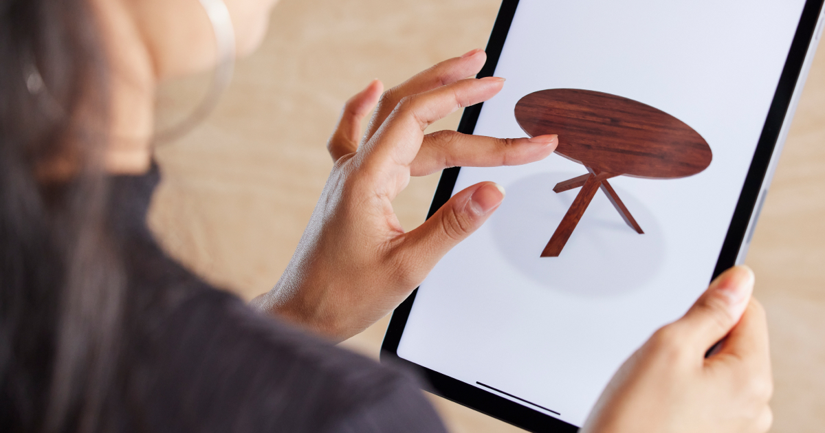 Person interacting with 3D visualization of a wooden table on a tablet device