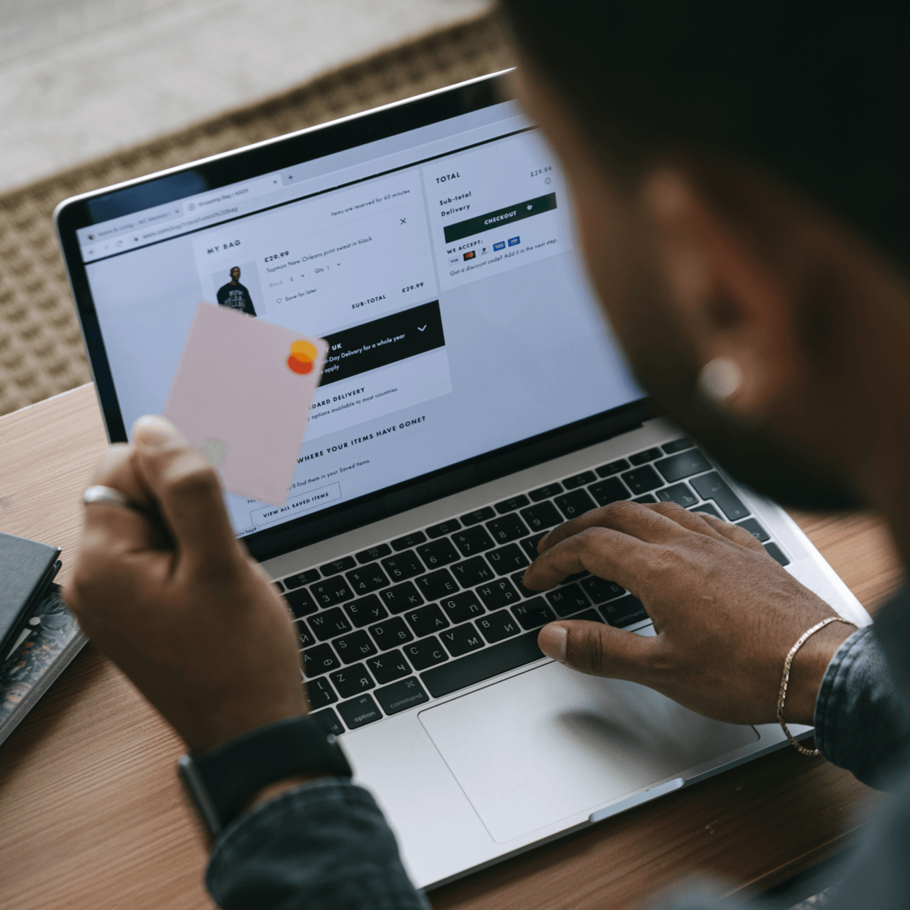 Person using bank card to make an eCommerce payment on their laptop